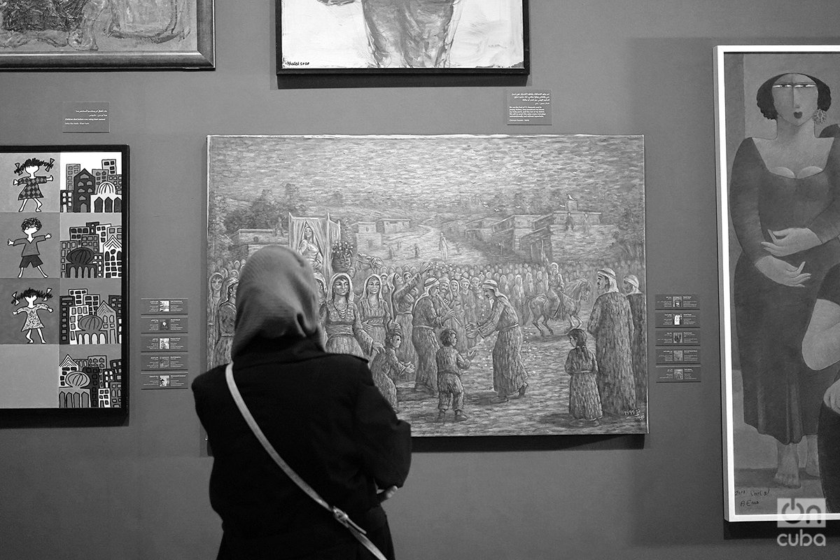 Una mujer palestina observa las obras de artistas gazatíes que se exponen en el Museo Palestino, en Birzeit, Cisjordania ocupada. Foto: Alejandro Ernesto.
