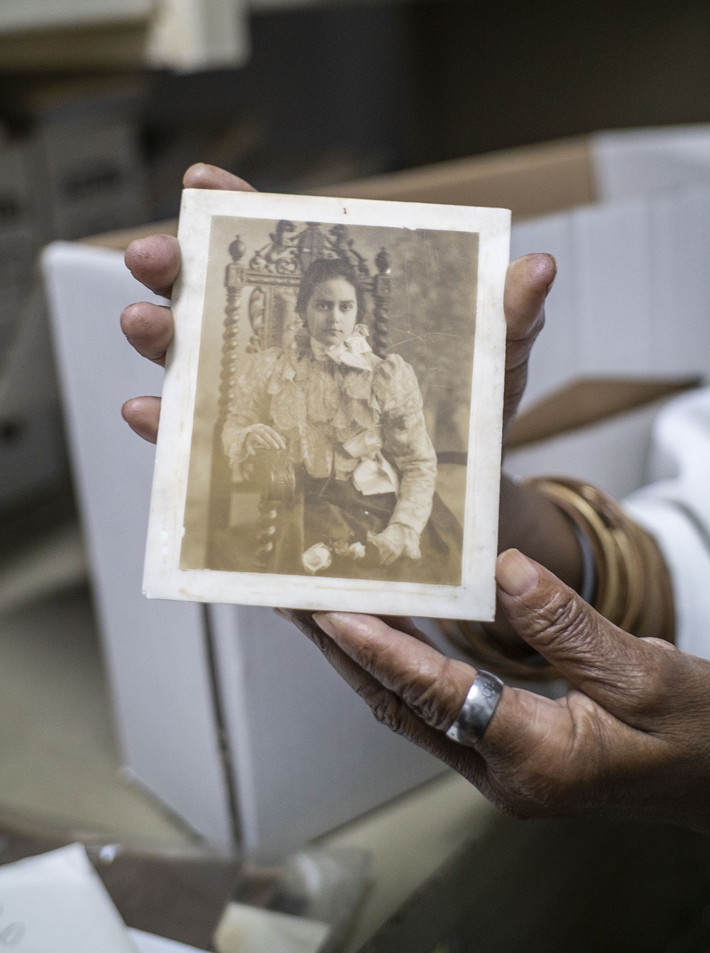 Marta, encargada de la Fototeca del Archivo Nacional de Cuba, muestra una fotografía en una placa de vidrio.