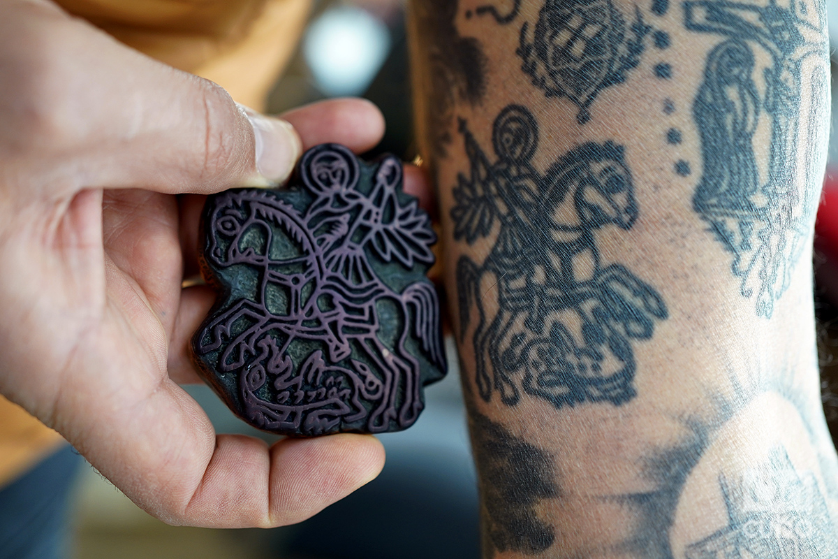 Wassim Razzouk muestra el sello original y el tatuaje de un San Jorge en su brazo. Foto: Alejandro Ernesto.