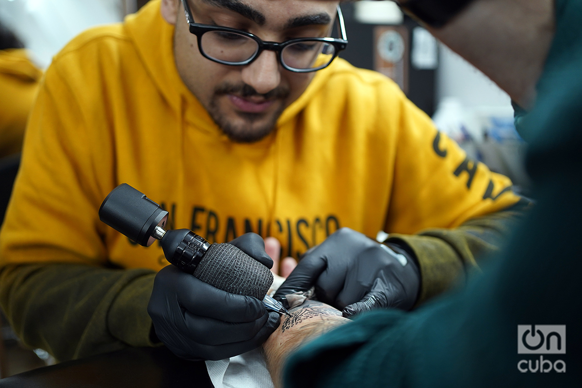 Nizar Razzouk tatúa un Árbol de la Vida en el brazo del estadounidens Ryan Coles. Foto: Alejandro Ernesto.