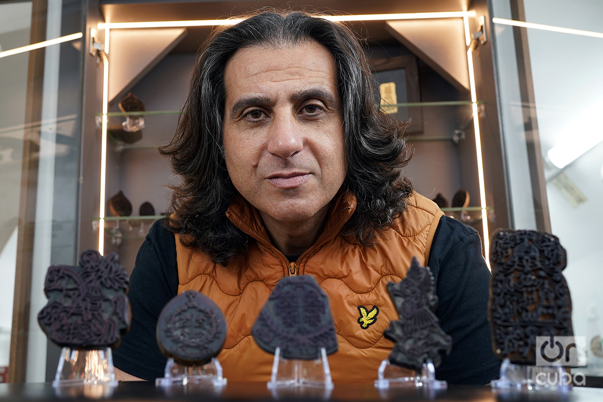 Wassim Razzouk, actual líder del clan de tatuadores, posa junto a su colección de sellos. Foto: Alejandro Ernesto.