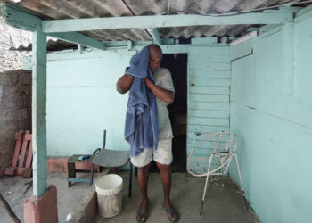 Un hombre se seca el sudor con una toalla, durante un apagón, en la entrada de su casa en el poblado de Santa Marta, Varadero, el pasado 12 de marzo. Foto: Yander Zamora/EFE.