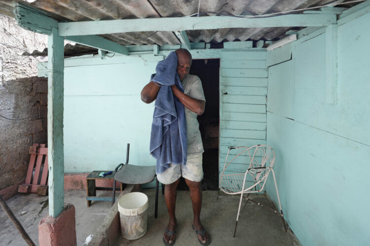 Un hombre se seca el sudor con una toalla, durante un apagón, en la entrada de su casa en el poblado de Santa Marta, Varadero, el pasado 12 de marzo. Foto: Yander Zamora/EFE.