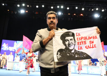 Maduro sosteniene una bandera con la imagen del fallecido Hugo Chávez este martes, en un acto de gobierno en Caracas. Foto: Palacio de Miraflores/EFE.