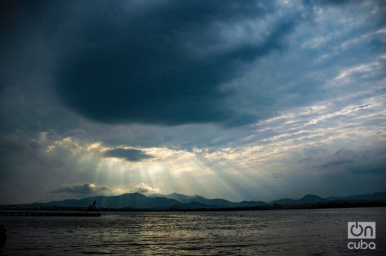 La luz se filtra entre las nubes en un atardecer en la Bahía de Santiago de Cuba. Foto: Kaloian.