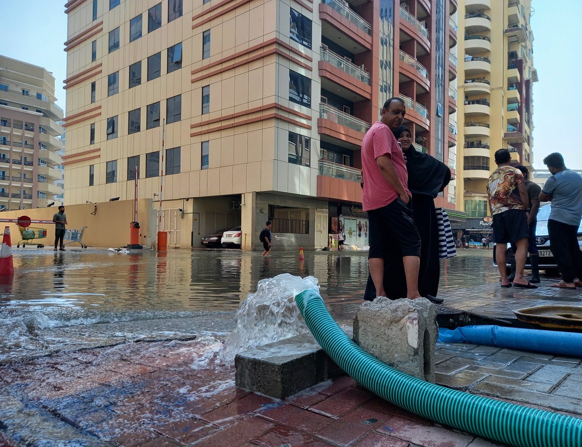 Mangueras vierten en la calle el agua de cisternas y sótanos inundados por las lluvias caídas una semana atrás en Dubái. Foto: OnCuba.