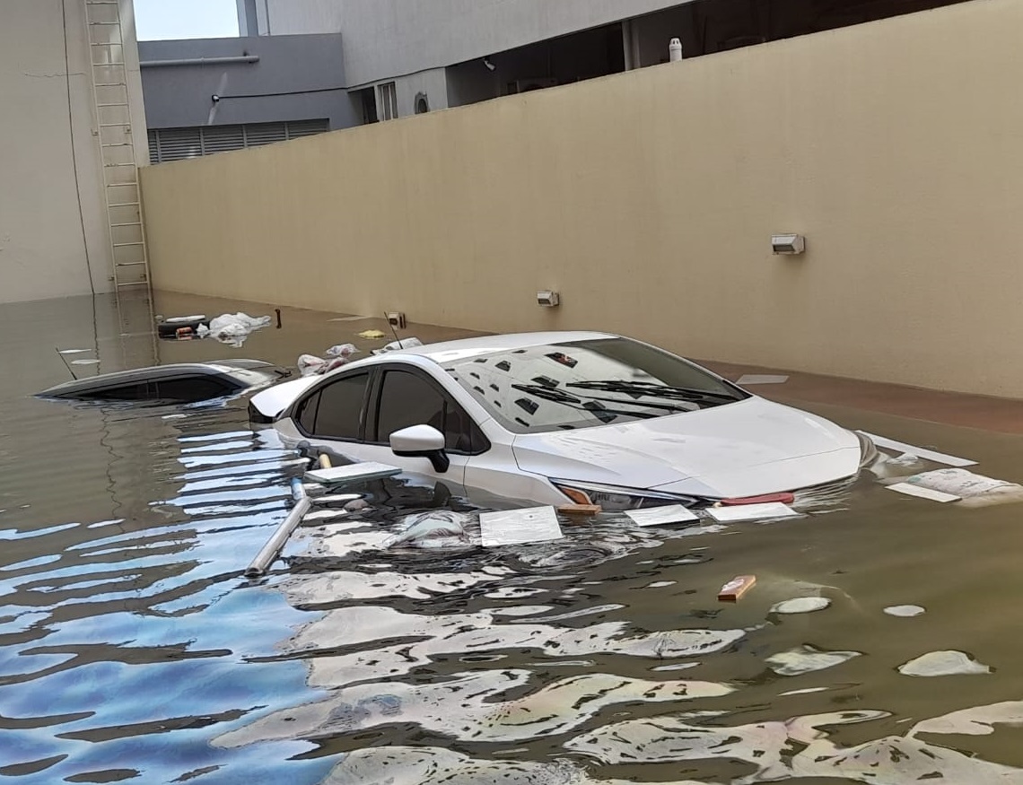 Autos inundados en el parqueo de un edificio en el barrio de Al Barsha, días después de las torrenciales lluvias caídas en Dubái. Foto: OnCuba.