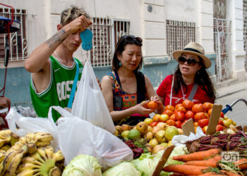 Turistas chinos compran a un carretillero en La Habana. Foto: Otmaro Rodríguez.