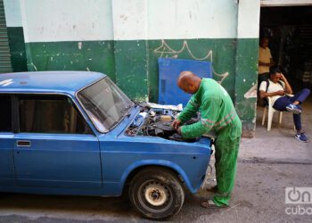 Un hombre repara un automóvil Lada en plena calle en La Habana. Foto: Alejandro Ernesto / Archivo.