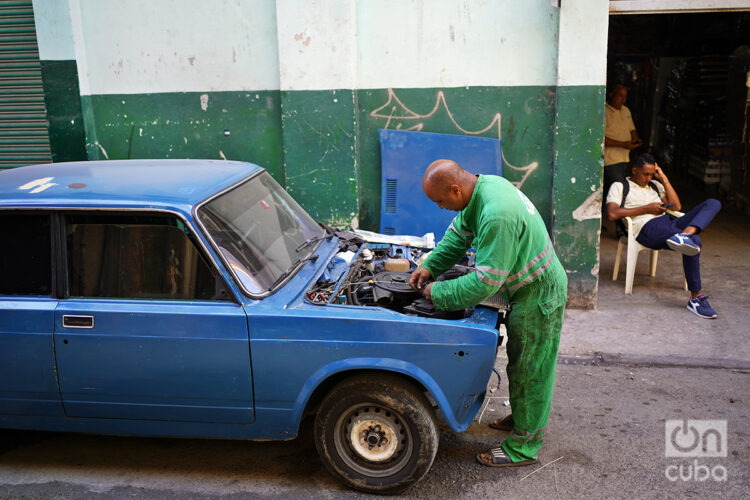 Un hombre repara un automóvil Lada en plena calle en La Habana. Foto: Alejandro Ernesto / Archivo.