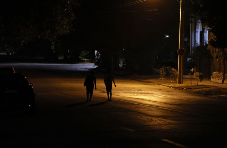 Personas caminan por una calle con poca iluminación el 17 de mayo de 2024 en La Habana (Cuba). Los prolongados apagones de los últimos días en Cuba alimentan las dudas sobre el plan del Gobierno para poner a punto el sistema eléctrico para julio y agosto, los meses de mayor calor y demanda, diseñado para cortocircuitar el vínculo entre cortes eléctricos y protestas. EFE/Ernesto Mastrascusa