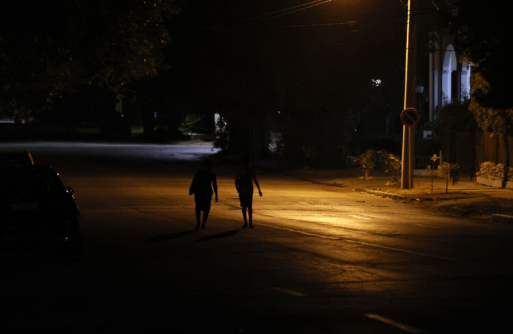 Personas caminan por una calle con poca iluminación en La Habana. Foto: Ernesto Mastrascusa/EFE.