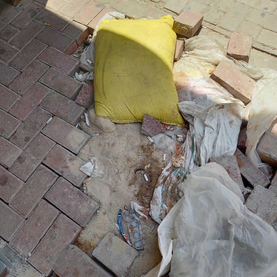 Una acera rota en Dubái, con sacos para cubrir el agujero, basura y colillas de cigarro. Debajo, la arena. Foto: Eric Caraballoso Díaz.