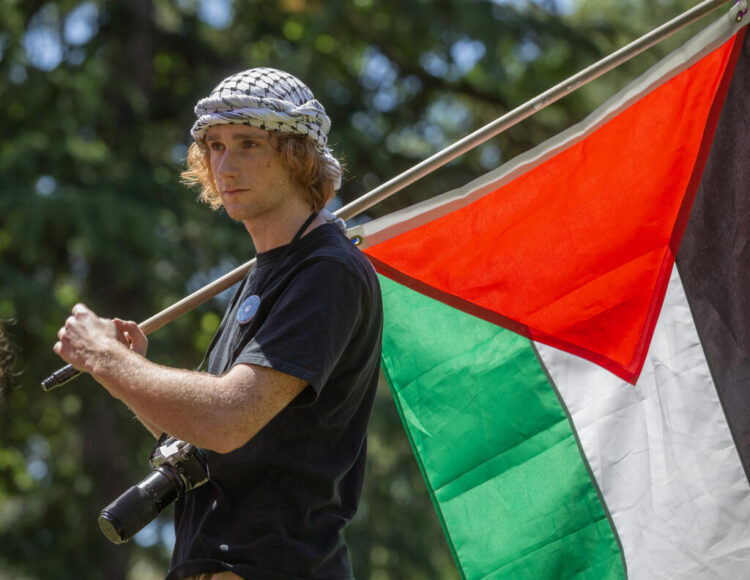 Julien Ducarroz, estudiante de Santa Rosa Junior College, porta una bandera palestina después de hablar durante una manifestación y protesta en apoyo de Gaza en el campus de Santa Rosa. Foto: Chad Surmick / The Press Democrat.