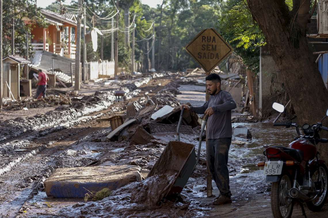 Un hombre retira el lodo que anegó su vivienda tras el desbordamiento del río Taquari, en Cruzeiro do Sul, estado de Rio Grande do Sul. Foto: EFE/ Sebastião Moreira.