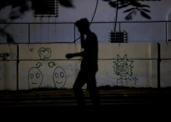 Una persona camina por una calle sin luz eléctrica, en La Habana. Foto: Ernesto Mastrascusa/EFE.