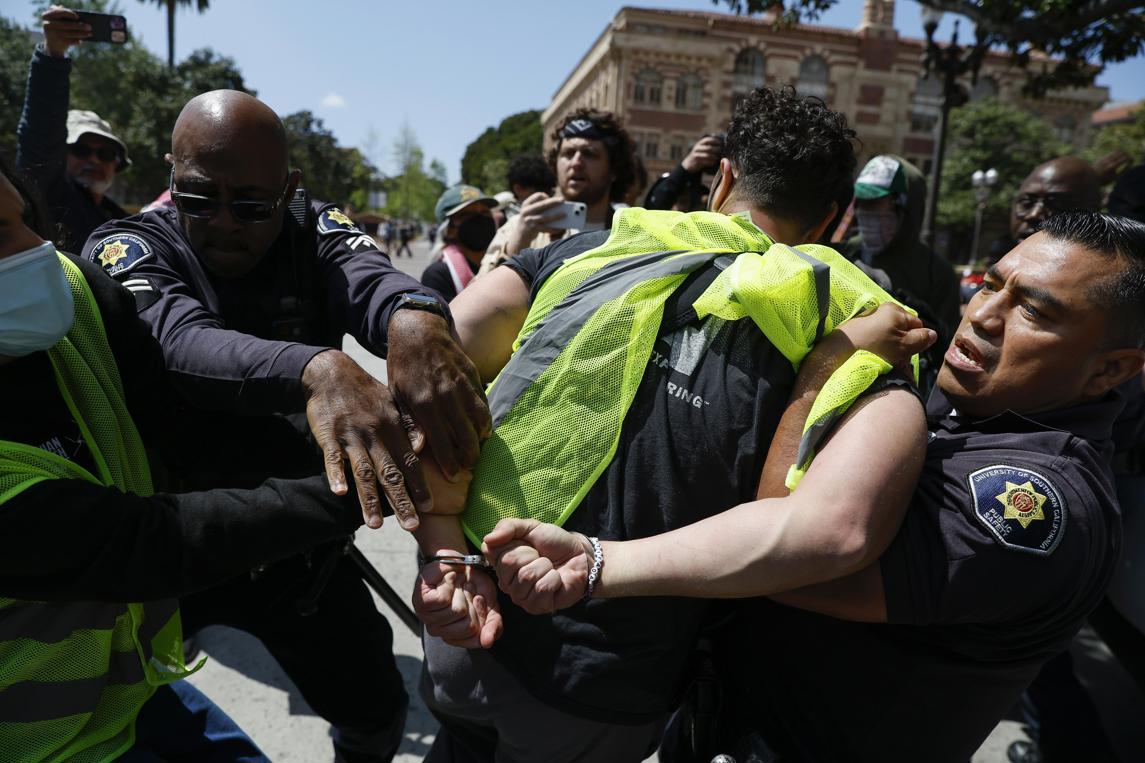 Oficiales de Seguridad Pública detienen a un manifestante durante una manifestación solidaria con Gaza en el campus de la 
Universidad del Sur de California. Foto: Caroline Brehman / EFE.