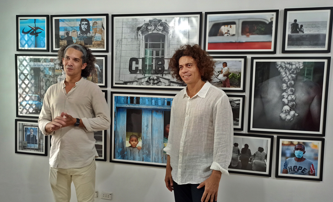 Yander Zamora (izq) y Roberto Ruiz (der) hablan durante la inauguración de Estudio Z, nuevo proyecto para la fotografía cubana, en La Habana. Foto: Ernesto Mastrascusa / EFE.