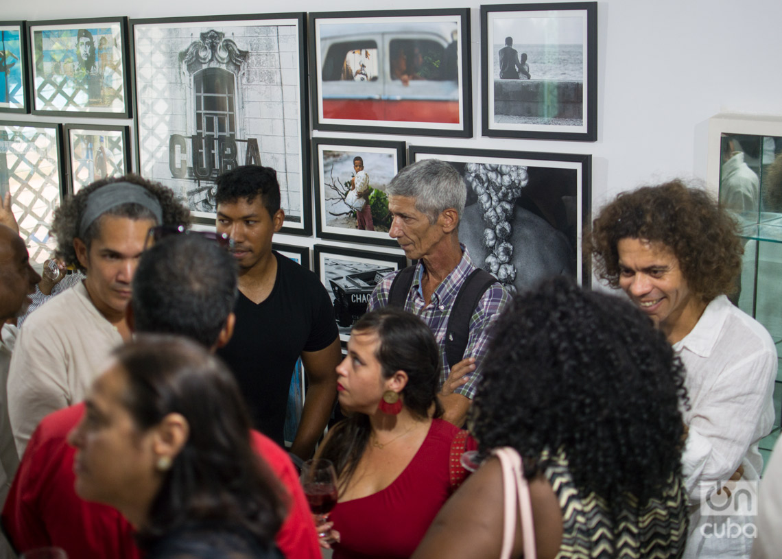 Inauguración de Estudio Z, proyecto de los fotógrafos Yander Zamora y Roberto Ruiz en La Habana. En los extremos con camisa blanca, Yander (izq) y Roberto (der), conversando con asistentes a la apertura. Foto: Otmaro Rodríguez.