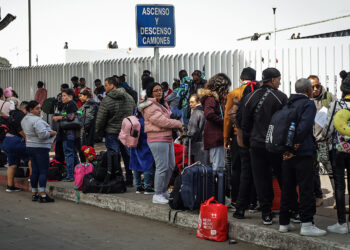 Migrantes esperan sobre una calle en la ciudad de Tijuana, Baja California (México). Foto: Joebeth Terríquez/EFE.