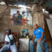 Dos hombres sentados junto a varias imágenes del fallecido líder cubano Fidel Castro y su hermano Raúl Castro al interior de una carpintería en La Habana. Foto: Yander Zamora / EFE.