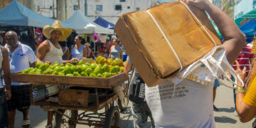 Un hombre carga una caja de pollo comprada en la calle Galiano, durante una feria este fin de semana. Foto: Otmaro Rodríguez.