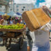 Un hombre carga una caja de pollo comprada en la calle Galiano, durante una feria este fin de semana. Foto: Otmaro Rodríguez.