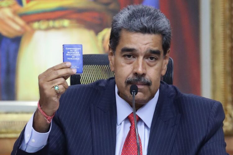 El presidente de Venezuela, Nicolás Maduro, sostiene la Constitución de la República Bolivariana de Venezuela durante una rueda de prensa este miércoles, en el Palacio de Miraflores en Caracas. Foto: Ronald Peña R. / EFE.