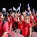 Asistentes al acto por el 26 de julio en Sancti Spíritus levantan banderas cubanas. Foto: @PresidenciaCuba / X.