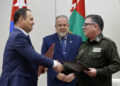 El primer ministro de Bielorrusia, Román Golovchenko (i), firma un acuerdo junto al Ministro del Interior cubano el General de Brigada Lázaro Alberto Álvarez Casas, en presencia del primer ministro cubano Manuel Marrero, en La Habana, el 16 de julio de 2024. Foto: Ernesto Mastrascusa / EFE.