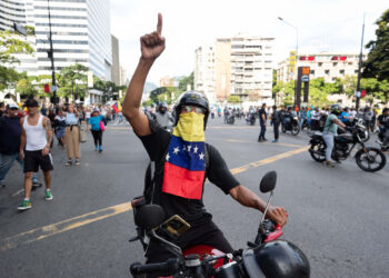 Un hombre en motocicleta participa en una protesta en Caracas por los resultados oficiales de las elecciones presidenciales en Venezuela, el 29 de julio. Foto: Ronald Peña / EFE.