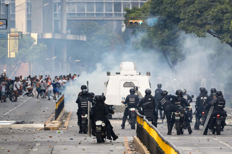 Integrantes de la Policía Nacional Bolivariana (PNB) y la Guardia Nacional Bolivariana (GNB) enfrentan a manifestantes opositores este lunes, durante una protesta contra de los resultados de las elecciones presidenciales, en Caracas. Foto:  Ronald Peña R/EFE.