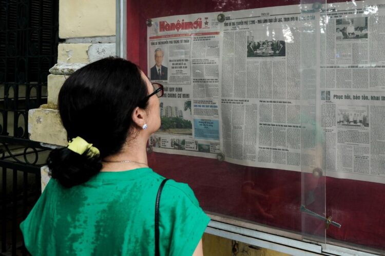 Una mujer lee sobre la muerte de Phu Trong en un periódico, este viernes en Hanói. Foto: LUONG THAI LINH/EFE/EPA.