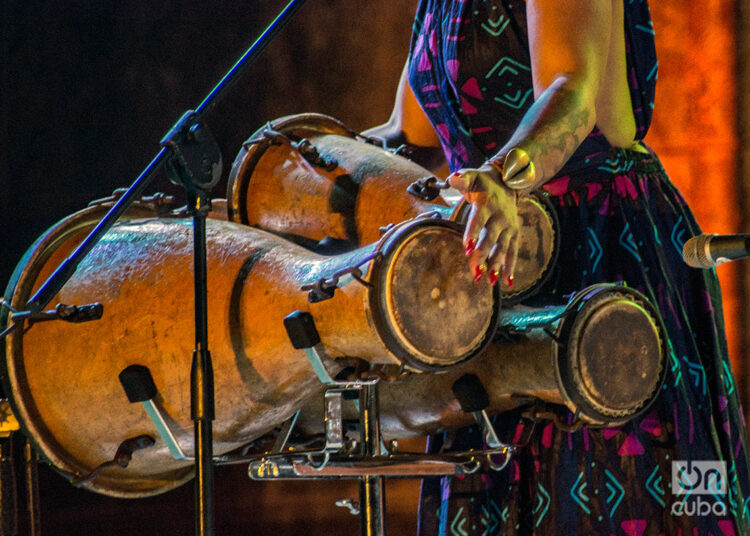 La percusionista y cantante Brenda Navarrete toca los tambores batá durante un espectáculo junto a la Agrupación Folklórica Iyerosun, en el Anfiteatro de La Habana Vieja, el 21 de agosto de 2024. Foto: Otmaro Rodríguez.