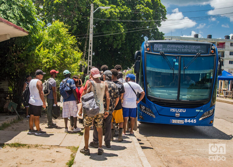 Personas hacen cola para subir a un ómnibus estatal en La Habana. Foto: Otmaro Rodríguez.