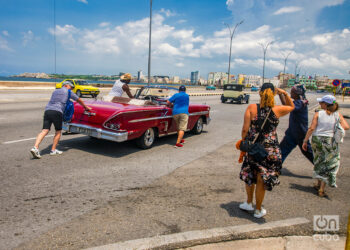 Turistas ayudan a empujar un auto clásico en La Habana. Foto: Otmaro Rodríguez.