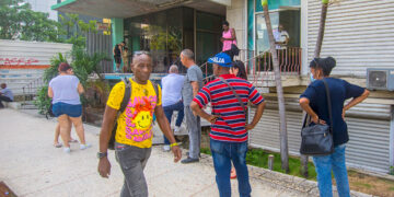 Personas caminan y hacen cola en una Cadeca en el Vedado. Foto: Otmaro Rodríguez.