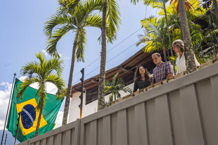 Claudia Macero (i), Pedro Uchurrurtu (c) y Magalli Meda, asilados en la residencia del embajador de Argentina, saludan desde un balcón con la bandera de Brasil a un costado. Foto: Henry Chirinos/EFE.