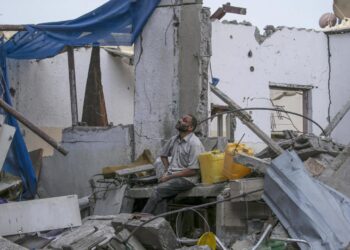 Palestino sentado en su casa familiar destruida tras un ataque aéreo israelí en el campo de refugiados de Al Maghazi, Franja de Gaza. Foto: Mohammed Saber / EFE.