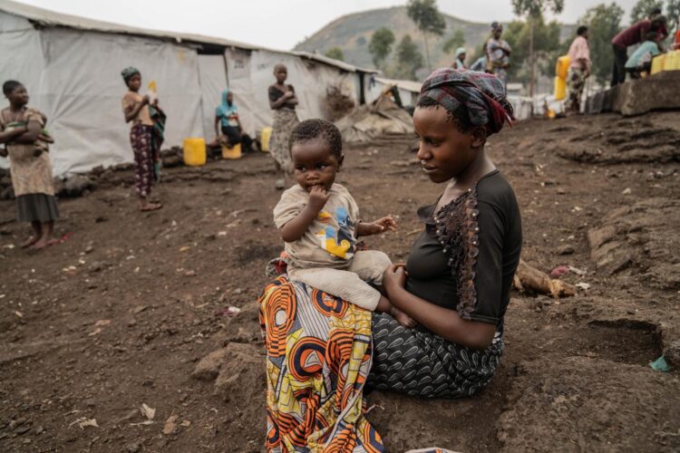 Tuliza Bisere sostiene a su hija Ishara que se curó de mpox pero aún muestra cicatrices de la enfermedad en el campo de desplazados internos de Mudja, República Democrática del Congo, 20 de agosto 2024. Foto: EFE/EPA/MOISE KASEREKA.