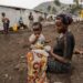 Tuliza Bisere sostiene a su hija Ishara que se curó de mpox pero aún muestra cicatrices de la enfermedad en el campo de desplazados internos de Mudja, República Democrática del Congo, 20 de agosto 2024. Foto: EFE/EPA/MOISE KASEREKA.