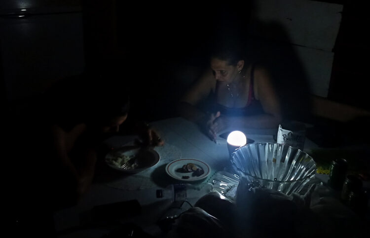 Una mujer conversando con su hijo durante un apagón, en La Habana. Foto: EFE/ Ernesto Mastrascusa ARCHIVO.