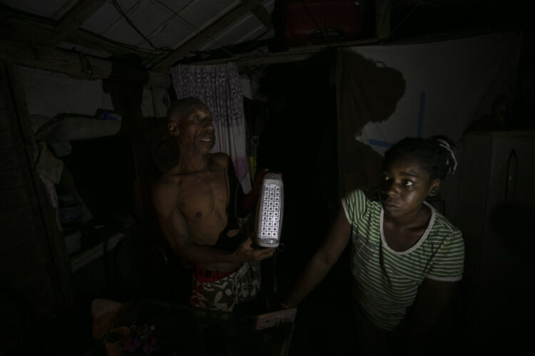 Víctor y Catalina muestran una lámpara led rota mientras hablan con EFE en su casa durante un apagón, en el poblado de Santa Marta, Varadero, en marzo de 2024. Foto: Yander Zamora/EFE.