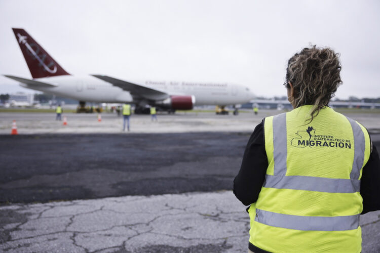 Trabajadora de migración observa el avión que transporta a los 135 nicaragüenses liberados este jueves, en el Aeropuerto Internacional La Aurora, en la Ciudad de Guatemala. Foto: Gobierno De Guatemala/EFE.