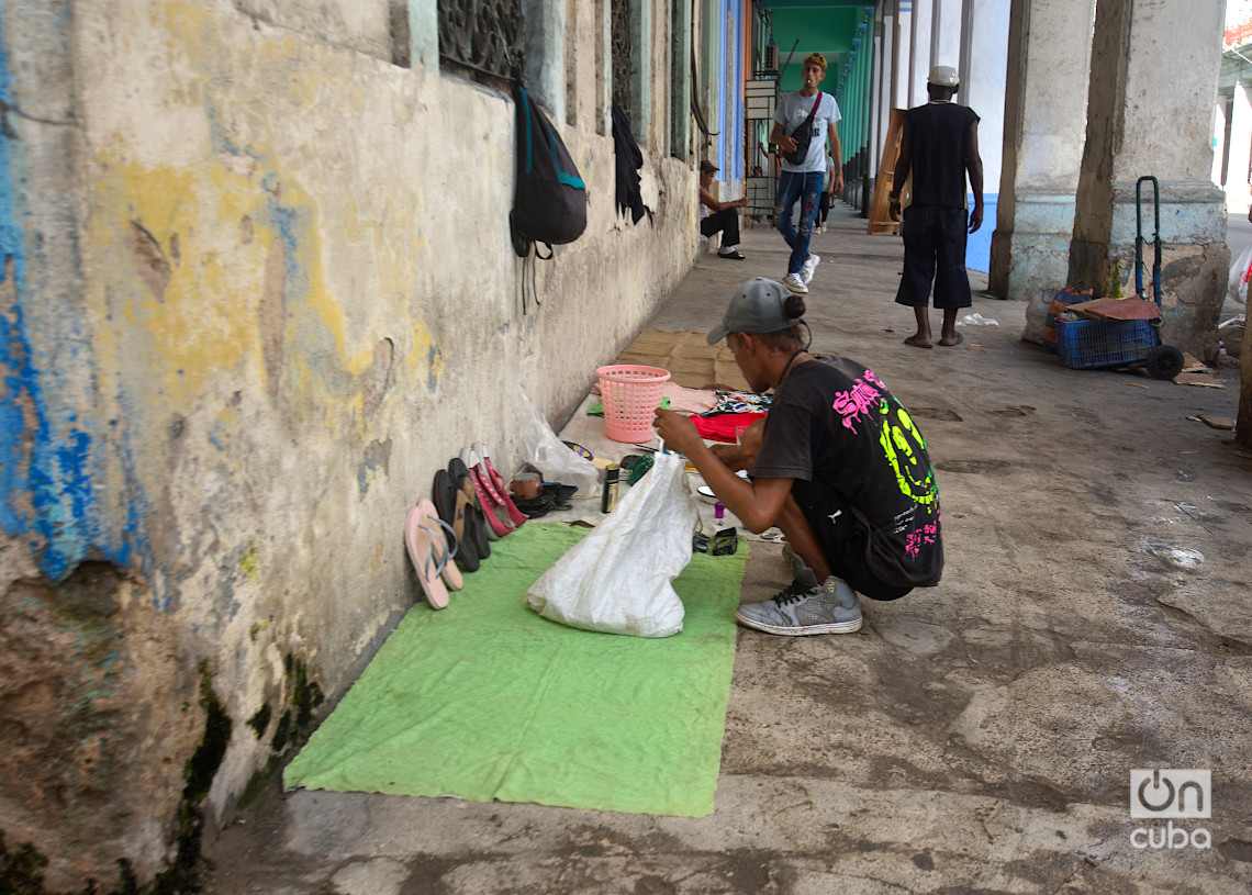 Un hombre prepara su lugar de venta en la calle Reina. Foto: Otmaro Rodríguez.