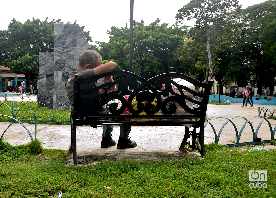 Vendedor callejero durmiendo en el parque del Curita a pleno día junto a sus pertenencias. Foto: Otmaro Rodríguez.