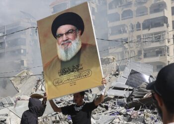 Un hombre muestra un retrato del asesinado líder de Hezbollah durante la embestida israelí en Beirut. Foto: Joao Relvas / EFE.