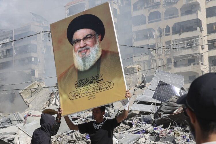 Un hombre muestra un retrato del asesinado líder de Hezbollah durante la embestida israelí en Beirut. Foto: Joao Relvas / EFE.