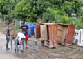 Varios hombres limpian unos armarios en la región de San Antonio del Sur una semana después del paso de la tormenta tropical Oscar. Foto: Ernesto Mastrascusa / POOL / EFE.