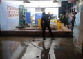 Un policía saca agua de una vivienda en la región de San Antonio del Sur una semana después del paso de la tormenta tropical Oscar. Foto: Ernesto Mastrascusa / POOL / EFE.